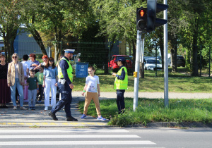 "Bezpieczna droga do przedszkola" - na zdjęciu przedszkolaki ćwiczą bezpieczne przechodzenie po pasach z sygnalizacją